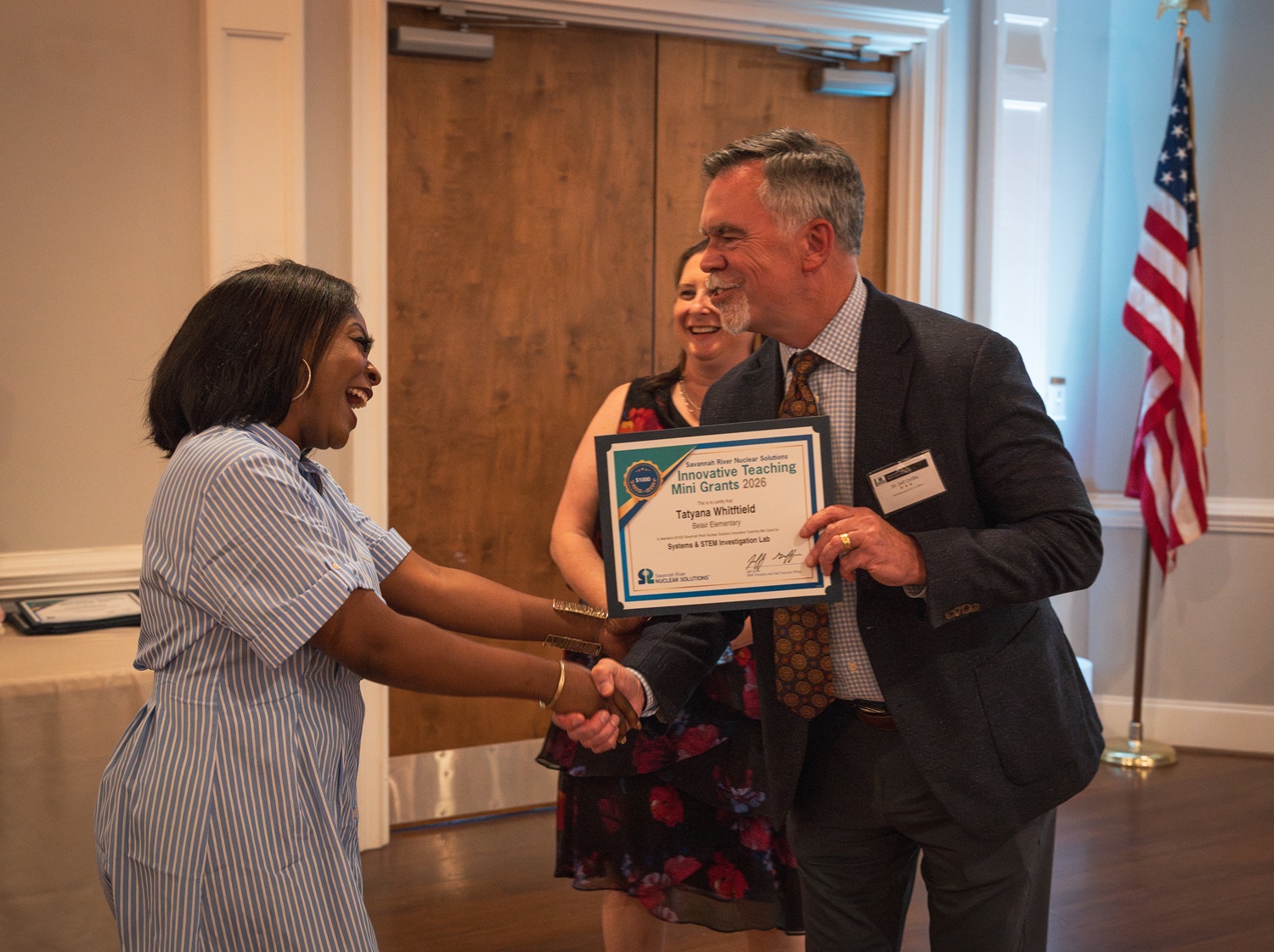 Jeff Griffin, SRNS President and Chief Executive Officer awards a ,000 Mini Grant to Belair Elementary Educator Tatyana Whitfield for a systems and STEM investigation lab experiment. Also pictured: Lindsey MonBarren, Manager, SRNS Corporate Communications.