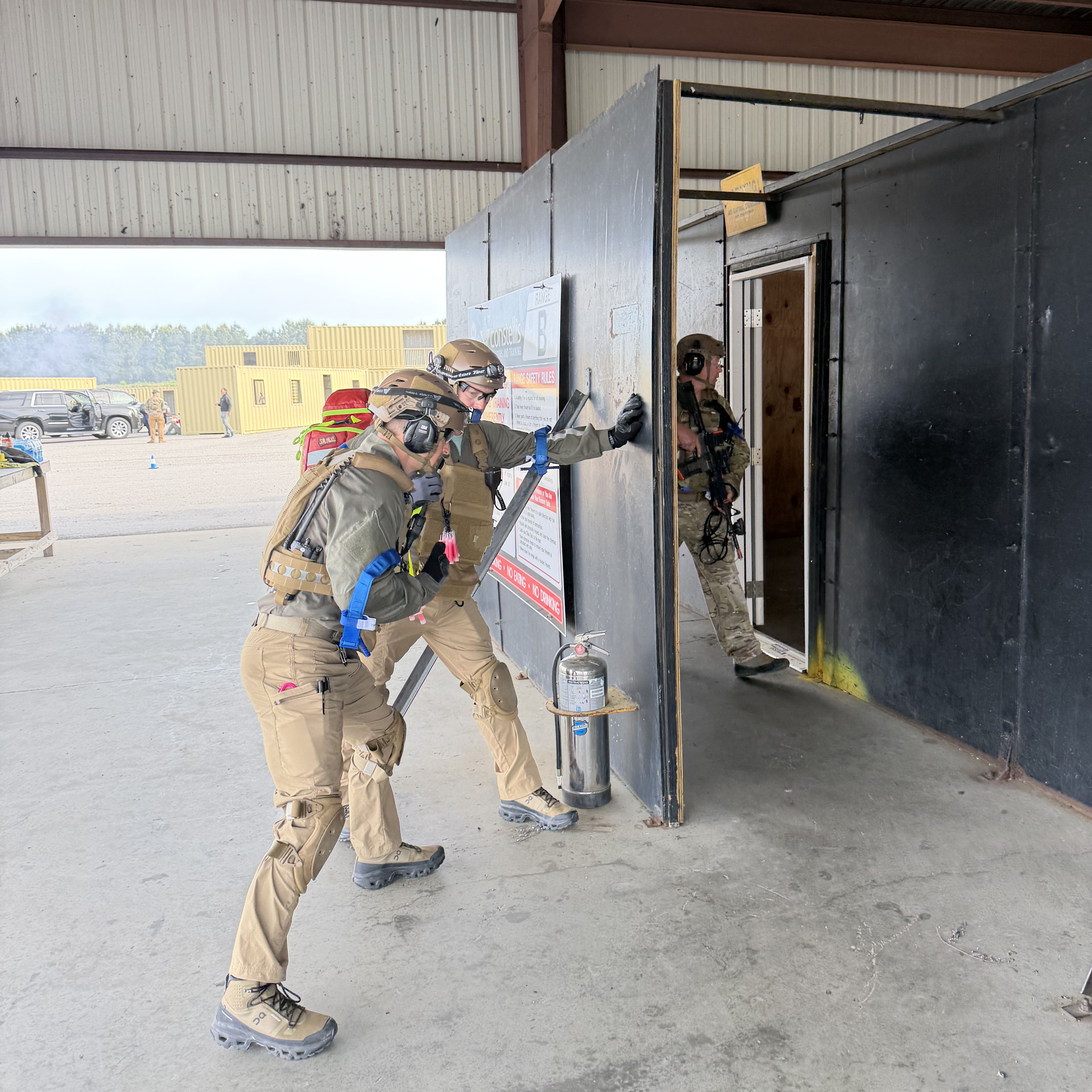 Jonathan Brown (left) and Justin Benton (far right) prepare to enter a shoot house—a realistic training environment used in active assailant response workshops to help participants practice quick and effective action in simulated threat scenarios.